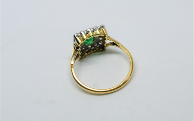 An 18ct Gold Emerald And Diamond Cluster Ring.
