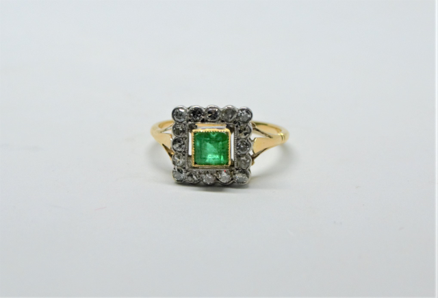 An 18ct Gold Emerald And Diamond Cluster Ring.