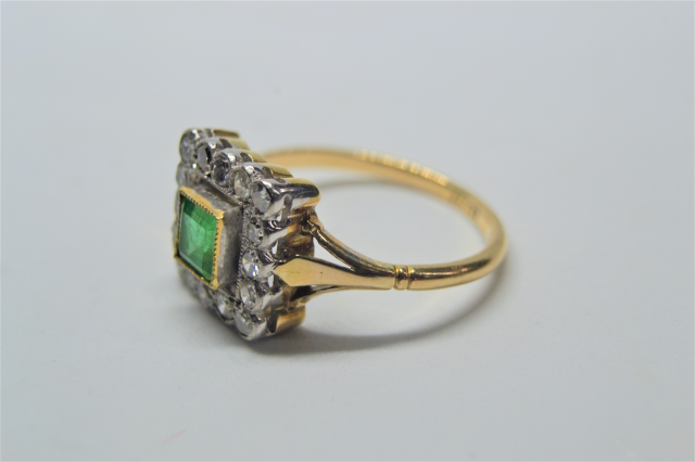 An 18ct Gold Emerald And Diamond Cluster Ring.
