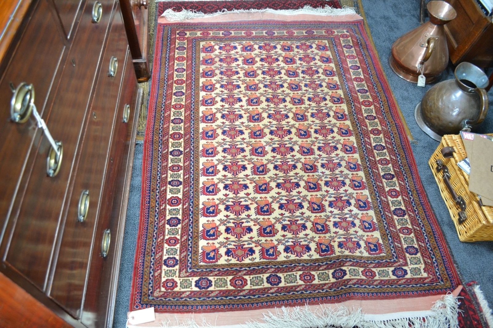 Turkish fringed carpet cream ground with designs in red and blue.