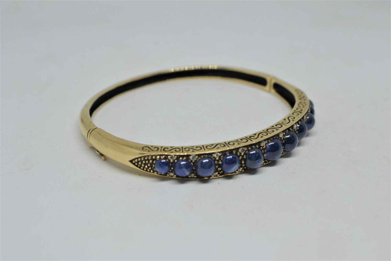 A 9ct yellow gold sapphire bangle