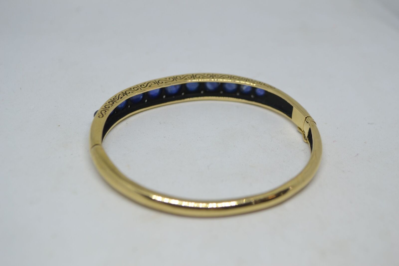A 9ct yellow gold sapphire bangle