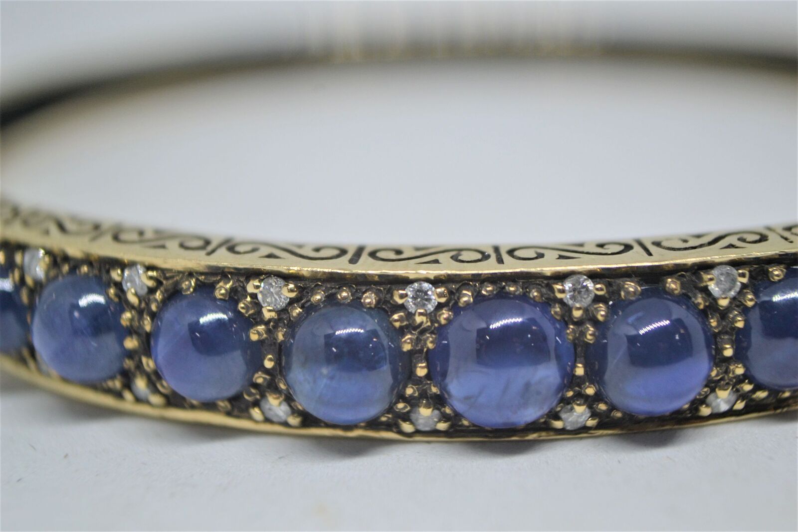A 9ct yellow gold sapphire bangle