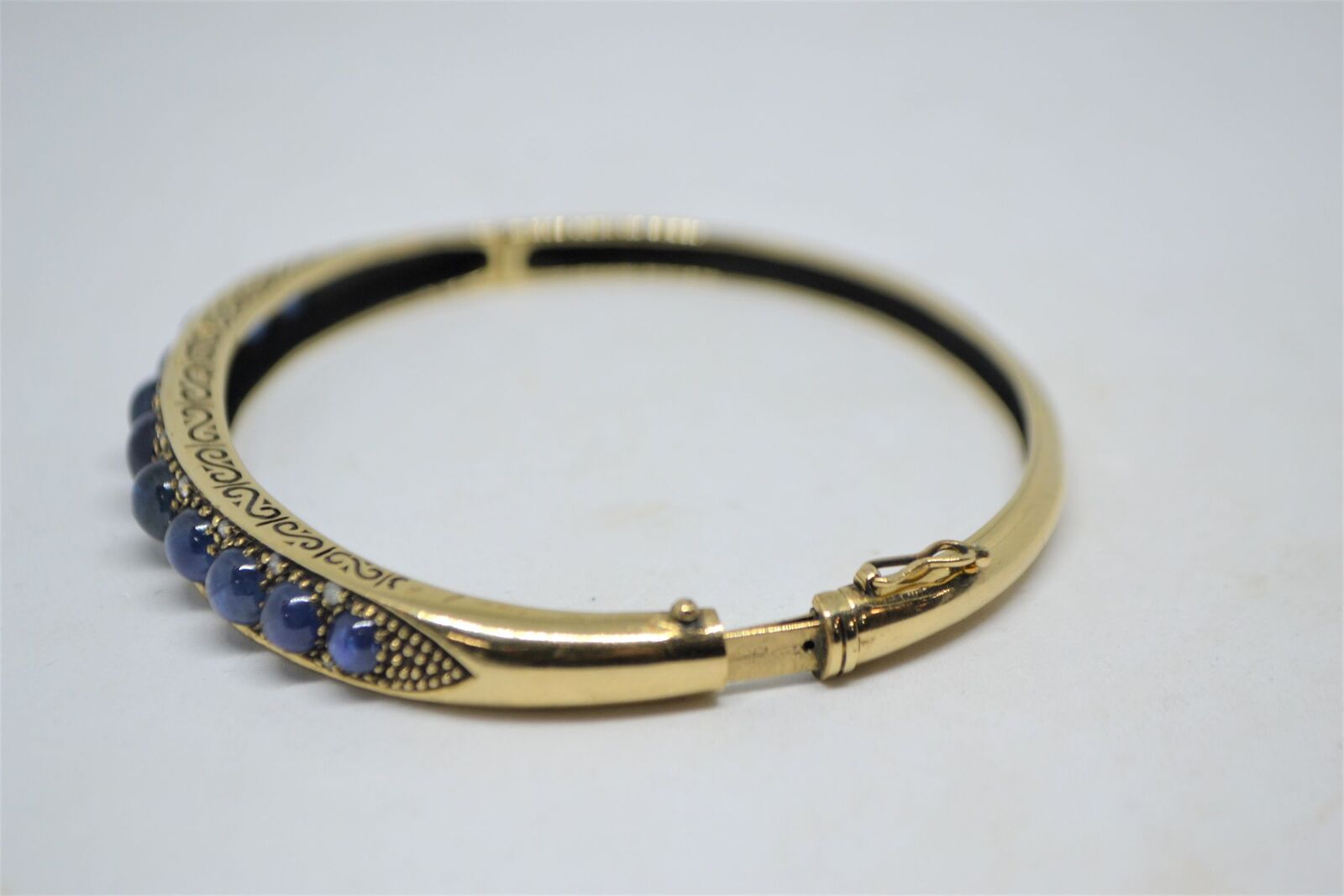 A 9ct yellow gold sapphire bangle